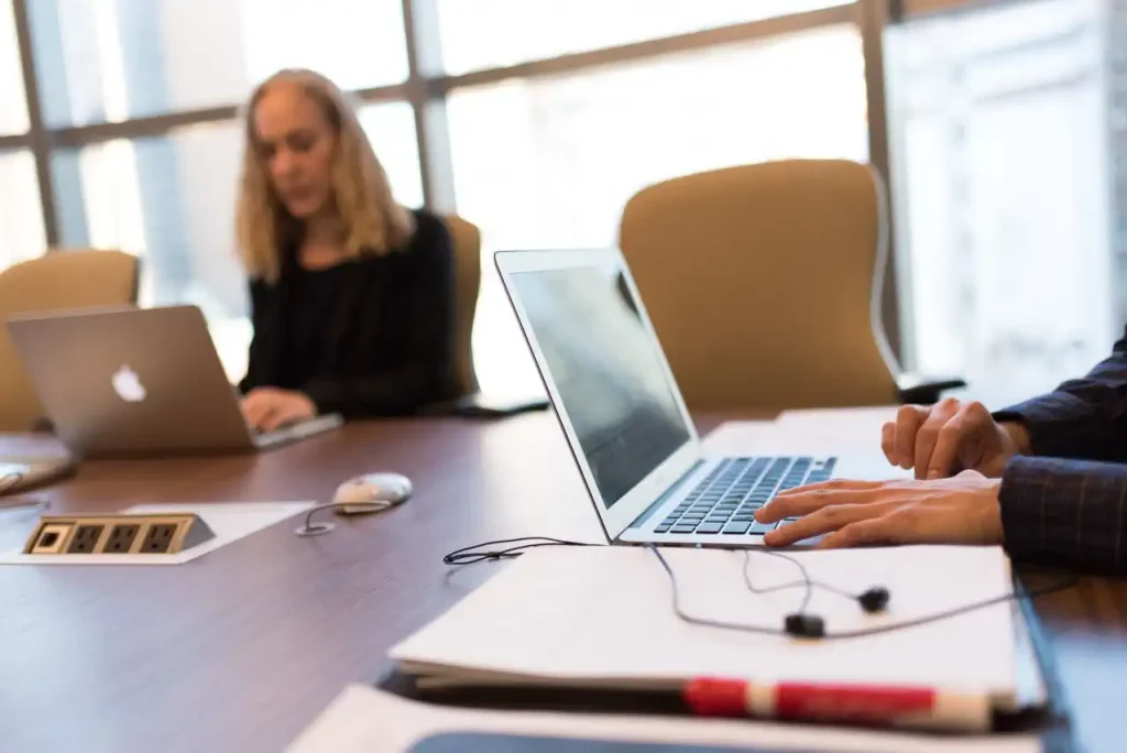 Reunião com pessoas à mesa em seus notebooks.