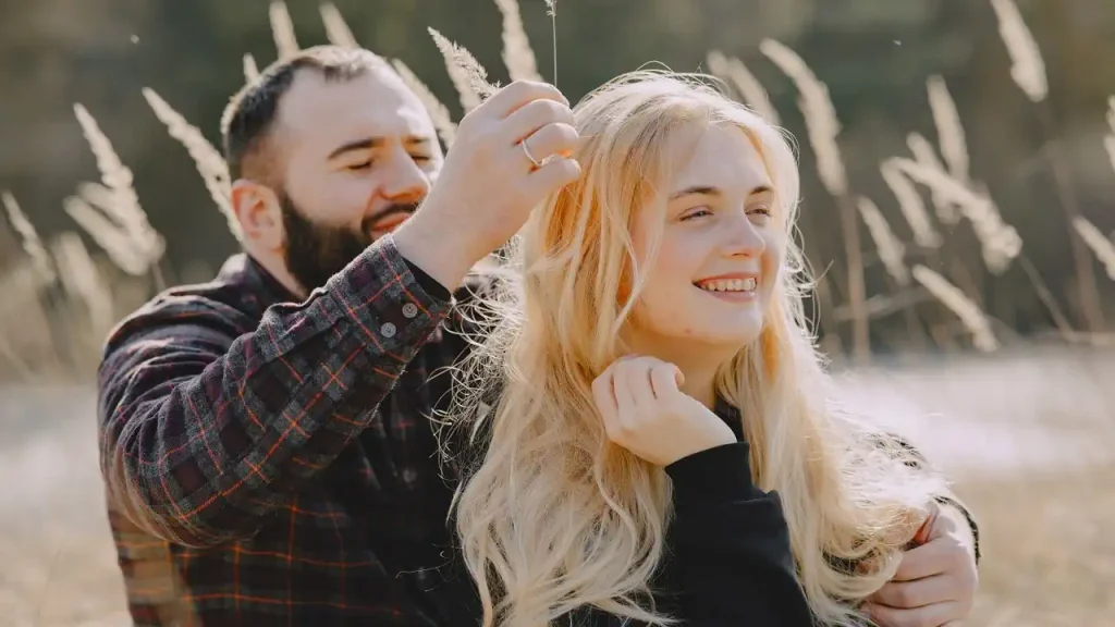 Homem mexendo no cabelo cortado de sua namorada.